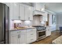 Modern kitchen featuring stainless steel appliances, granite countertops, and white cabinets at 2075 Toad Hollow Trl, Apex, NC 27502