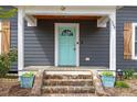 Close-up of the front door with its stylish, light blue color and stone steps at 208 S Guthrie Ave, Durham, NC 27703