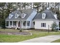 Traditional home showcasing a covered front porch, dormer windows, and a well-manicured front lawn at 218 Keith Hills Rd, Lillington, NC 27546