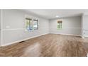 Bright living room with new wood floors and large windows to let the light shine in at 251 W Moffitt Avenue, Liberty, NC 27298