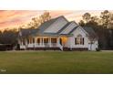 Well-maintained home with a charming porch, classic siding, and a neatly manicured lawn at 2905 Glendale Rd, Kenly, NC 27542