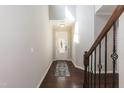 Bright foyer featuring hardwood floors, a staircase with iron railings, and a front door at 3011 September Dr, Durham, NC 27703