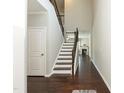 Staircase with hardwood treads, white risers, and dark wood railing with wrought iron spindles at 3011 September Dr, Durham, NC 27703
