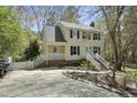 Traditional two-story home with vinyl siding, a charming front door, driveway, and mature trees at 323 Brandermill Dr, Durham, NC 27713