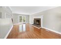 Cozy living room features a brick fireplace, hardwood floors, and French doors leading to the outside at 323 Brandermill Dr, Durham, NC 27713