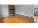 Spacious living room with a brick fireplace and gleaming hardwood floors at 324 Dare St, Burlington, NC 27217