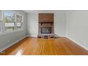 Bright living room featuring a brick fireplace, large windows, and hardwood floors at 324 Dare St, Burlington, NC 27217