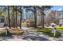 Stately two-story home with a long driveway and mature trees, showcasing its curb appeal at 3424 English Cir, Willow Springs, NC 27592