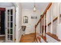 Inviting foyer features hardwood floors, staircase with white railings, and classic light fixture, creating a warm welcome at 4217 Pike Rd, Raleigh, NC 27613