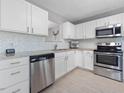 Kitchen featuring stainless appliances, ample granite countertops, and white cabinets, offering a clean and modern aesthetic at 5 Maidenhair Ct, Durham, NC 27703