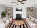 Bright living room featuring stylish decor, a fireplace, and a ceiling fan for added comfort at 5005 Baywood Forest Dr, Knightdale, NC 27545