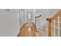Bright foyer features hardwood floors, a staircase, and a glass-paneled door providing access to other rooms at 5033 Homeplace Dr, Apex, NC 27539
