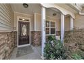 Inviting front porch with stone accents, a brown door, and manicured landscaping creates curb appeal at 5033 Homeplace Dr, Apex, NC 27539