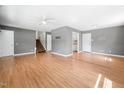 Spacious living room with light wood flooring, gray walls, and a staircase at 506 N Harrison Ave, Cary, NC 27513