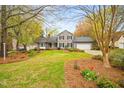 Charming two-story home with gray siding, black shutters, attached garage and landscaped front yard at 516 Edinburgh Dr, Burlington, NC 27215