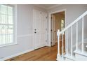 Bright foyer featuring hardwood floors, staircase, white trim, and a view into the rest of the home at 5209 Rivington Rd, Fuquay Varina, NC 27526