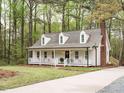 Quaint home featuring a welcoming front porch, complemented by a classic brick chimney and beautiful setting at 5209 Rivington Rd, Fuquay Varina, NC 27526