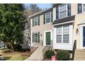 Inviting two-story townhome with beige siding, complemented by green shutters, and a well-maintained front yard at 5551 Vista View Ct, Raleigh, NC 27612