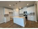 Modern kitchen featuring white cabinets, stainless steel appliances, and a stylish island at 609 Callan View Ave, Wake Forest, NC 27587