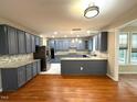 Well lit kitchen with stainless steel appliances, granite countertops and hardwood floors at 6705 Somerknoll Dr, Durham, NC 27713