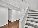 Clean hallway and staircase with hardwood floors, white walls, and modern lighting at 717 E Millbrook Rd, Raleigh, NC 27609