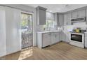 Modern kitchen featuring stainless steel appliances, gray cabinets, and a bright window at 717 E Millbrook Rd, Raleigh, NC 27609