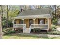 Home featuring a covered front porch with white railings and stained shutters, offering a cozy and classic appeal at 7317 Mill Ridge Rd, Raleigh, NC 27613