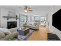 Bright living room with a white brick fireplace, hardwood floors, and open access to the dining area at 7317 Mill Ridge Rd, Raleigh, NC 27613