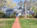 Inviting brick home featuring blue shutters, a vibrant green lawn, and a welcoming brick walkway at 806 S First St, Smithfield, NC 27577
