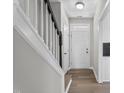 Entryway boasts hardwood floors and a white front door with glass transom window for natural light at 8700 Leeds Forest Ln, Raleigh, NC 27615