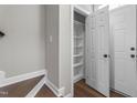 Hallway with hardwood floors showcases a storage closet and a door to the outside at 8700 Leeds Forest Ln, Raleigh, NC 27615