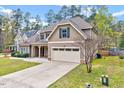 A view of the side of the house with its two-car garage, driveway, and some landscaping at 8932 Buffalo Gourd Ln, Angier, NC 27501