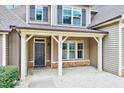 Inviting covered front porch with brick base columns and a dark-colored front door at 8932 Buffalo Gourd Ln, Angier, NC 27501