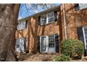 Brick townhome displaying black shutters, a tree, and a landscaped lawn at 103 Friar Ln, Carrboro, NC 27510