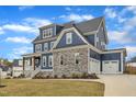 Eye-catching blue home with stone accents, covered porch, and attached two-car garage on a well-maintained lawn at 1160 Duke Farm Dr, Wake Forest, NC 27587