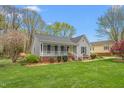 Charming single story home with a well-maintained lawn, inviting porch, and attractive landscaping at 124 Holly Ridge Ln, Mebane, NC 27302