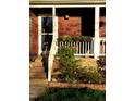 Inviting front porch with brick steps, white railings, and flourishing flower boxes at 125 Long Shadow Pl, Durham, NC 27713