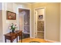 Hallway with hardwood floors, neutral walls, and decorative floral arrangements at 125 Long Shadow Pl, Durham, NC 27713