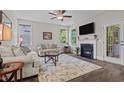 Bright living room with dark wood floors, a fireplace, recessed lighting, and an outdoor view at 128 School Side Dr, Spring Lake, NC 28390