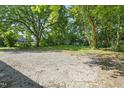 Large gravel parking pad and expansive lawn create an ideal space for entertaining at 129 Burwell Avenue Ave, Henderson, NC 27536