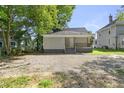 Back of house showing small porch and ample parking with trees and shrubbery at 129 Burwell Avenue Ave, Henderson, NC 27536