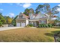 Charming two-story home featuring brick and siding, a two-car garage, and manicured landscaping at 1312 Golden Bluff Ln, Fuquay Varina, NC 27526