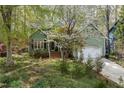 Green home featuring a well-manicured lawn and blooming trees adding curb appeal at 1550 Pathway Dr, Carrboro, NC 27510
