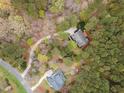 Beautiful aerial shot of the home nestled amongst many trees in a lush landscape and a winding driveway at 160 Sweet Pine Cir, Pittsboro, NC 27312