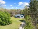 Captivating aerial shot of a charming home surrounded by lush greenery and a bright blue sky backdrop at 163 Ridge Way Ln, Clayton, NC 27520