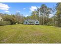 Expansive front yard with a quaint home featuring blue accents, offering serene suburban living at 163 Ridge Way Ln, Clayton, NC 27520