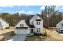 Beautiful two-story house showcases white siding, a dark roof, two-car garage and a well kept lawn at 201 W Amber Oak Drive, Selma, NC 27576
