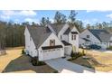Stunning exterior of a home with white siding, a dark roof, well manicured yard and a paved driveway at 201 W Amber Oak Drive, Selma, NC 27576