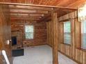 Interior view with log walls and exposed beams leading to a room with windows at 207 High House Rd, Cary, NC 27513