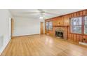 Spacious living room features a brick fireplace, wood paneling, and hardwood flooring at 209 High House Rd, Cary, NC 27513